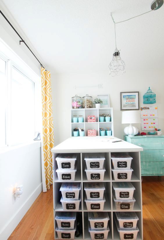 a large crafting table with shelves and boxes inside plus chalkboard labels