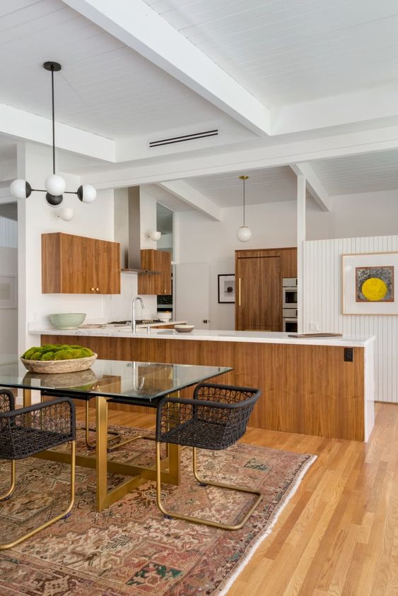 a large mid-century modern kitchen with wooden cabinets, white backsplashes and countertops