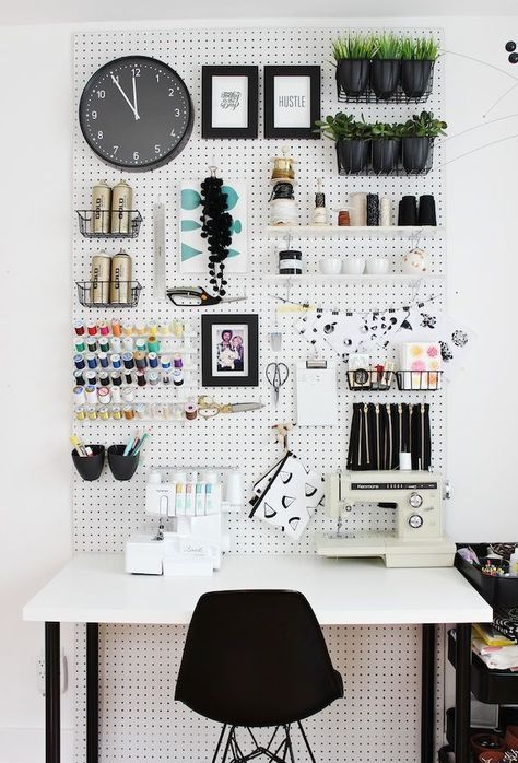 a monochromatic space with a pegboard done with shelves, wire baskets, containers and hooks