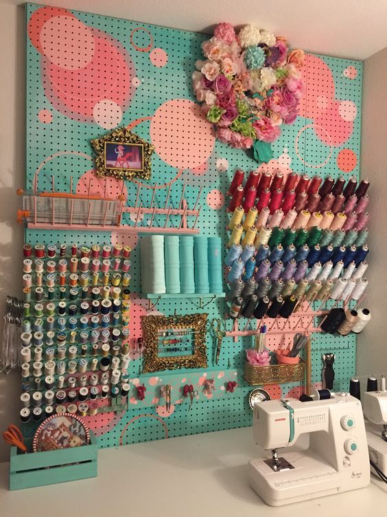 a painted pegboard with shelves, ledges, hooks and other stuff for sewing supplies