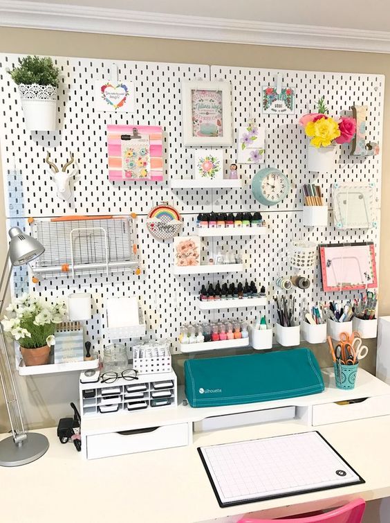 a pegboard with lots of shelves, storage containers and even planters attached to it