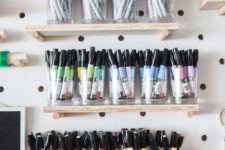a pegboard with shelves and glasses with markers will help you organize them all