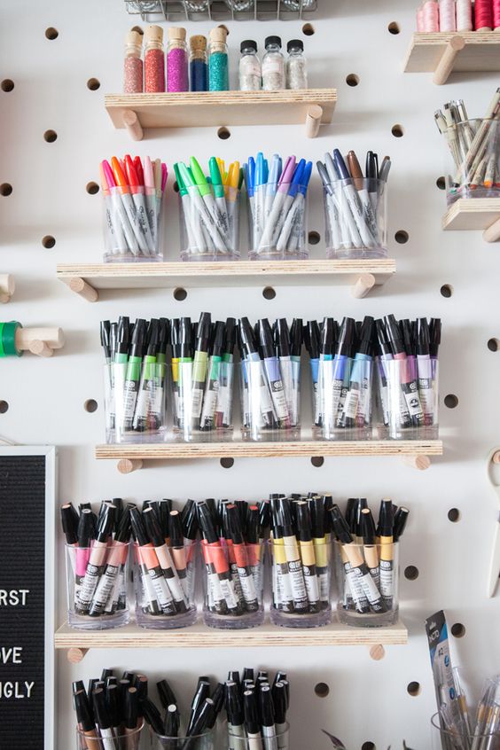 a pegboard with shelves and glasses with markers will help you organize them all