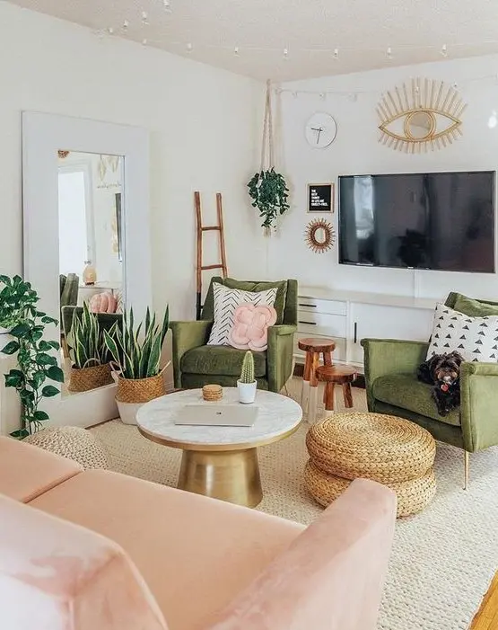 A pretty mid century modern living room with grene chairs, a blush loveseat, a round table and woven poufs, potted plants and lights