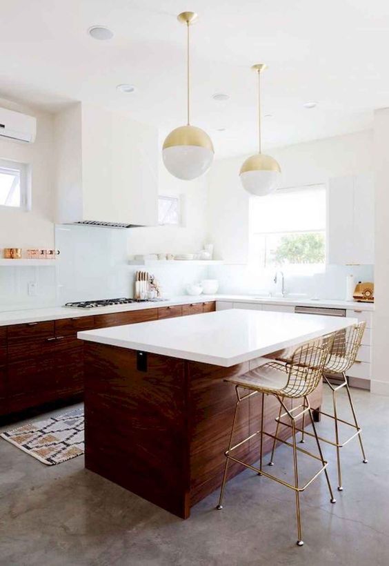 a rich-stained mid-century modern kitchen with white countertops, a white hood and pendant sphere-shaped lamps