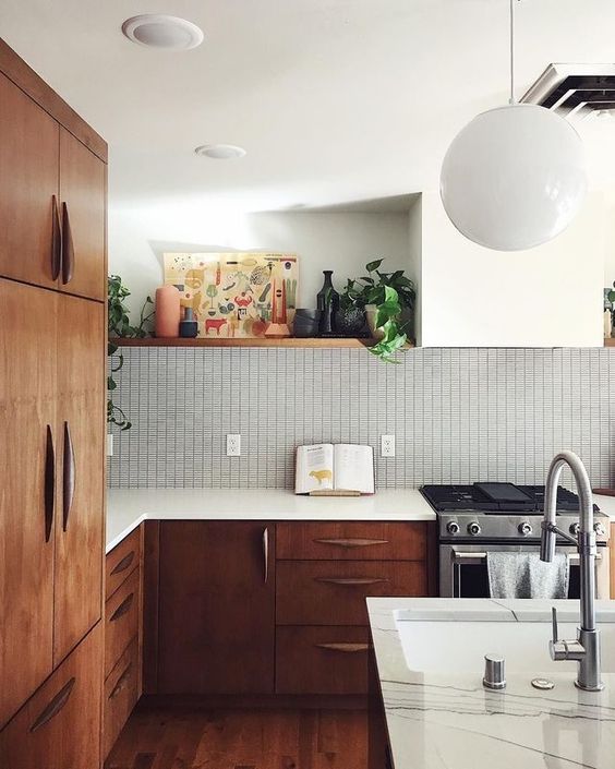 a rich-stained wood mid-century modern kitchen with white countertops, a graphic tile backsplash