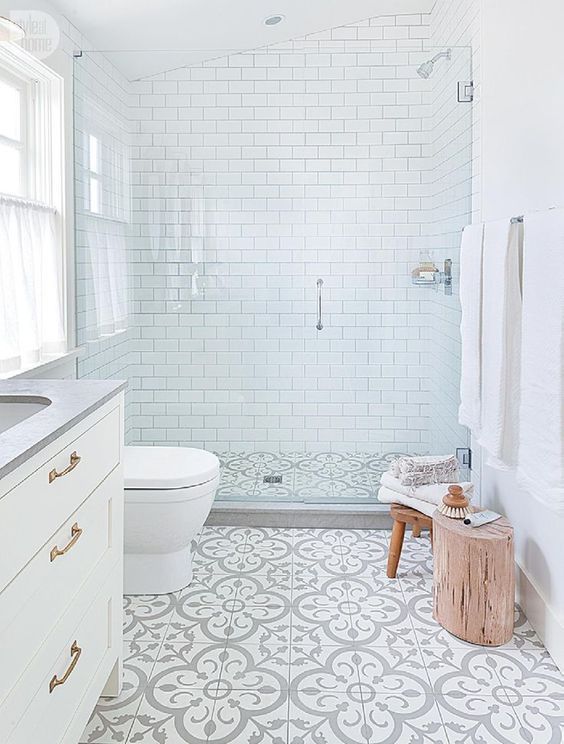 A serene mid century modern bathroom with subway and mosaic tiles, a tree stump and touches of brass for elegance
