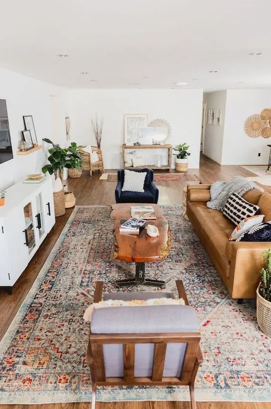 a stylish mid-century modern farmhouse living room with a leather sofa, elegant chairs, a living edge table, potted plants