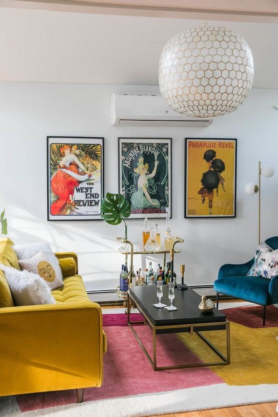 a vibrant living room with a bold rug, a mustard sofa and a navy chair, a chic coffee table and a bar cart plus a bold gallery wall