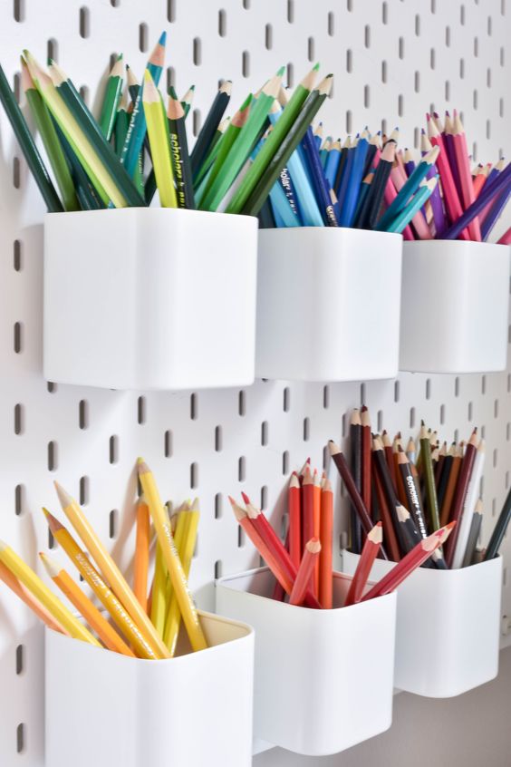 a white pegboard with pen holders is a cool idea for those who draw or write much