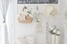 a white shabby chic entryway with a chic chalkboard sign, a whitewashed bench, blue curtains and baskets
