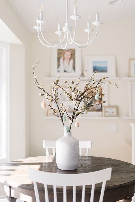 a Scandinavian Easter tree - white vase with blooming branches and pastel fake eggs is very chic