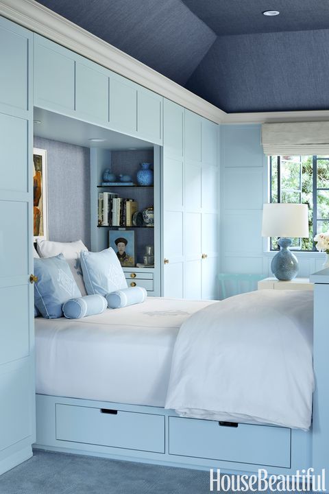 A built in powder blue bed with a couple of visible drawers is a cool storage idea for a small bedroom in any style