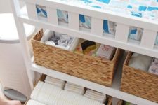 a changing table with basket boxes to store all the necessary stuff to change diapers