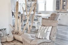 a coastal space with neutral wicker chairs, baskets for storage, a piece of wood with whitewashed branches, wicker lampshades