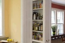 a doorway in the kitchen with hidden drawers built-in is a very cool idea to declutter the room and organize a small pantry right here