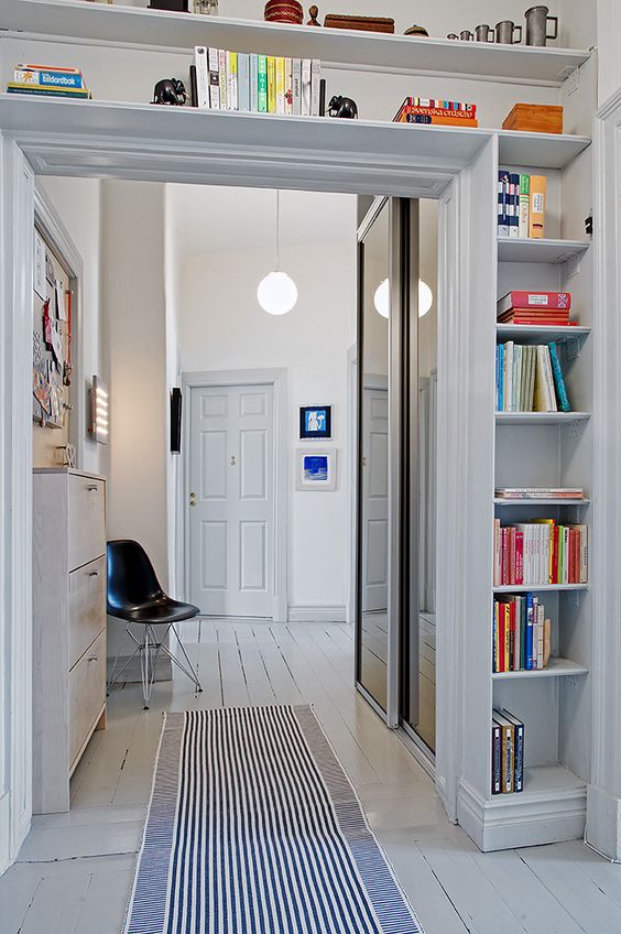 a doorway with open shelves coering the whole space over it is a cool idea to store some things and use the unused space