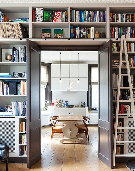 a doorway with open shelves over the door and around it is like organizing a whole library around the door without wasting floor space