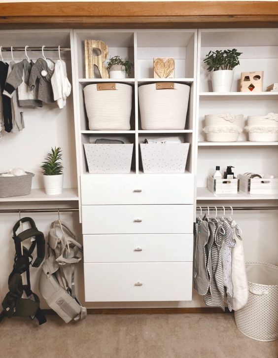 a large closet with a dresser, fabric baskets, planters and clothes hangers looks neat and chic
