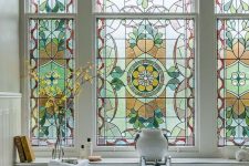 a large stained glass bathroom window is a beautiful vintage-inspired feature and a chic statement for a space
