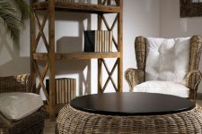 a lovely reading and sitting nook with wicker chairs and a round coffee table, a wooden shelving unit and a potted tree