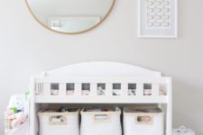 a modern white changing table with fabric baskets to organize some stuff and store it comfortably