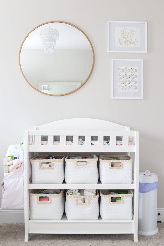 a modern white changing table with fabric baskets to organize some stuff and store it comfortably