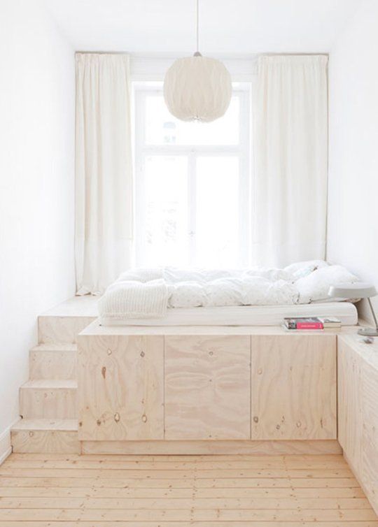 a risen bed with large hidden storage units inside it is a lovely idea for a tiny bedroom