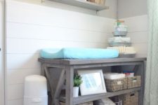 a rustic changing table with basket boxes for storage and organization