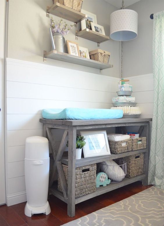 a rustic changing table with basket boxes for storage and organization