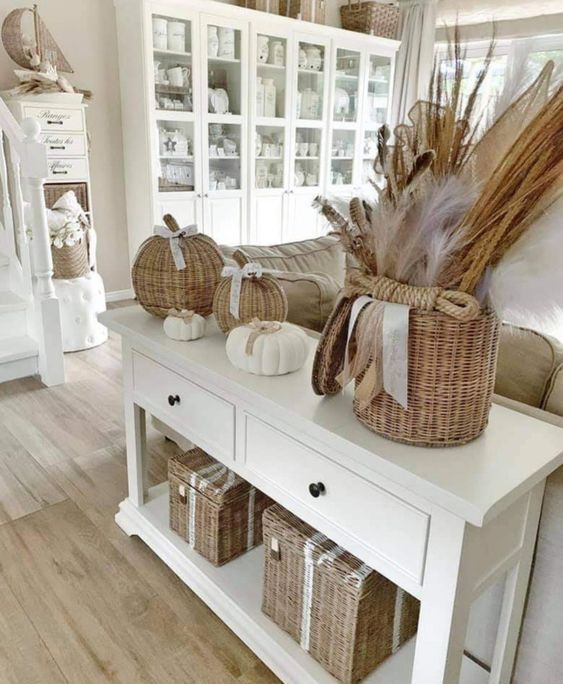 beautiful rustic fall home decor with wicker chests for storage, a basket with grasses, wicker pumpkins and white ones is cool