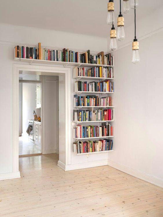 bookshelves covering one wall next to the doorway and a space over it will give you much space for books and will help you declutter the space