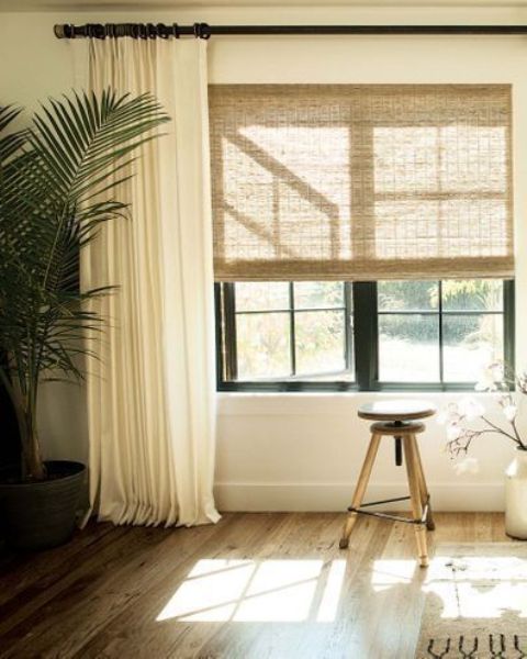 Neutral woven shades paired with creamy curtains look very nice and keep the space all private and welcoming