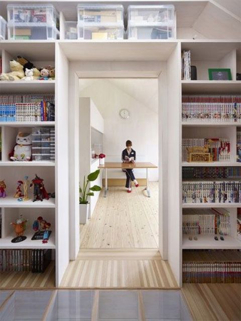 Open shelves surrounding the doorway are used for storing kids' stuff   books, toys and other things in boxes is a smart idea to organize the space