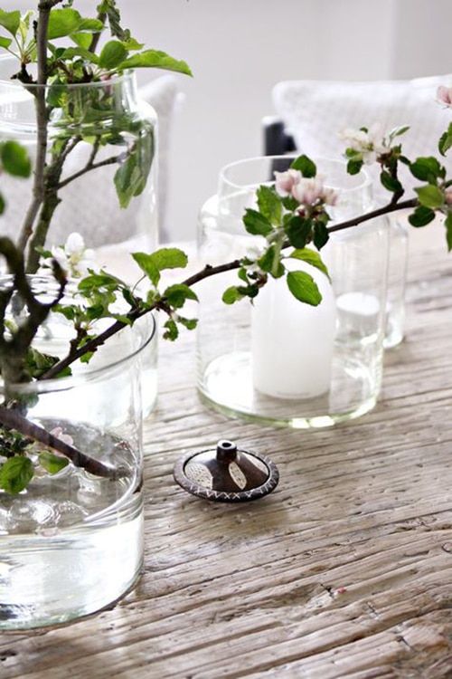 spring Scandinavian decor with a vase with vases with candles, a glass vase with blooming branches
