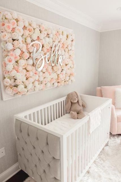 a beautiful girl nursery with light grey walls, white and pink furniture, a floral artwork and neutral bedding