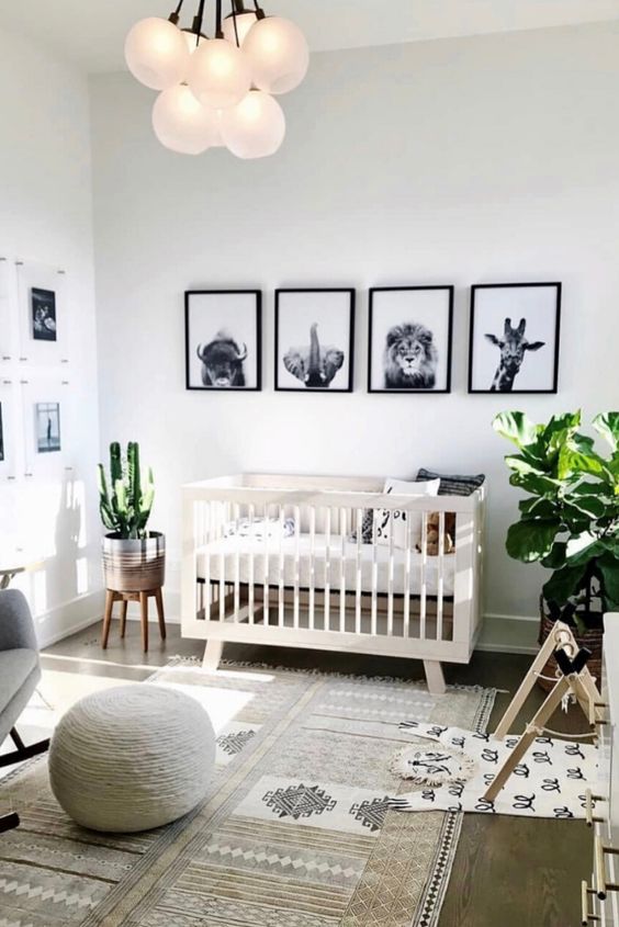a chic gender neutral nursery with neutral furniture, printed textiles, gallery walls and a catchy chandelier