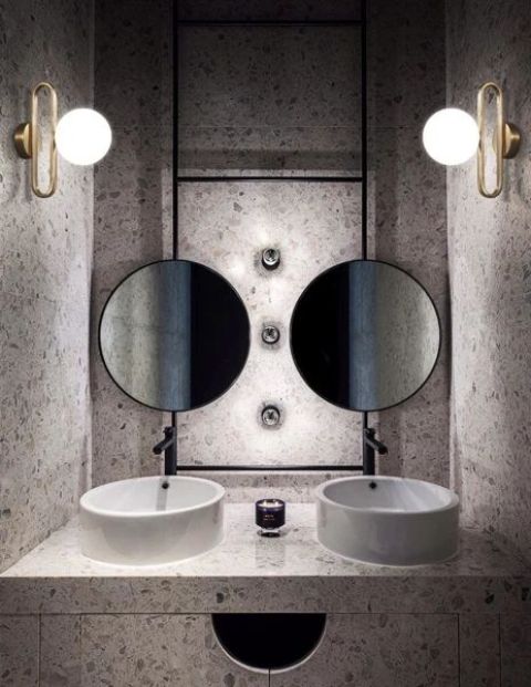 a duo of brass and glass sphere wall lamps echoes with round mirrors and sinks and looks hot