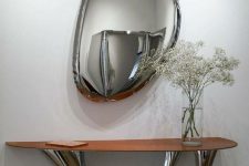 a fantastic pebble-shaped mirror reminds of liquid metal on the wall and looks gorgeous and edgy for a modern space
