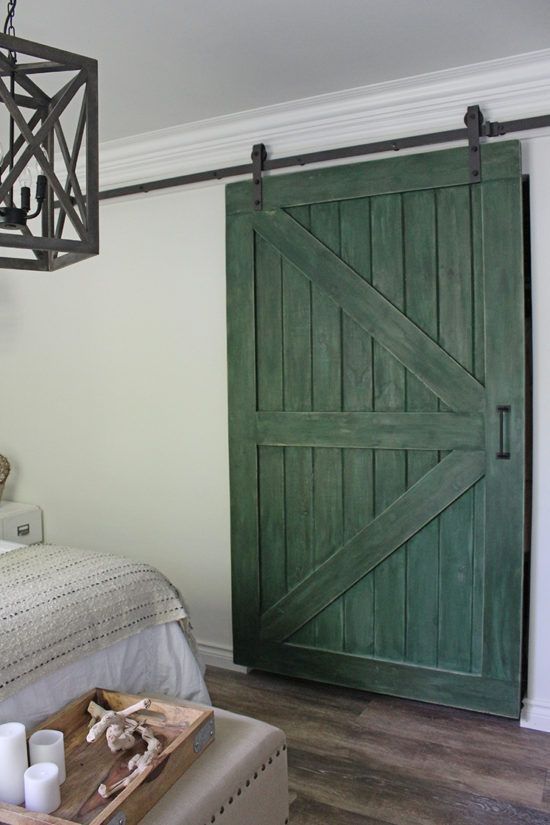 a green sliding barn door adds color and rustic chic to the space