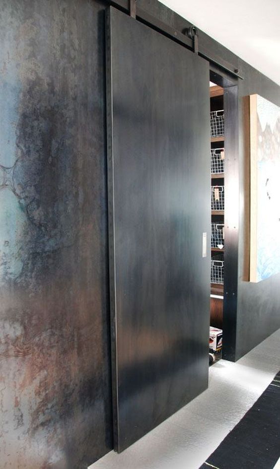a metal sliding door continues the industrial and rough decor theme of the space