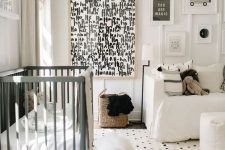 a monochromatic nursery with printed textiles and a graphic artwork, neutral and green furniture and paneling on the wall