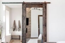 a rustic weathered wooden door with a large mirror brings a rustic feel and a cozy touch
