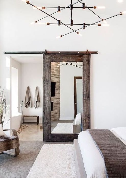 a rustic weathered wooden door with a large mirror brings a rustic feel and a cozy touch