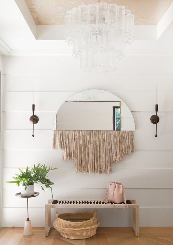 A semi circle mirror with long neutral fringe is a lovely solution for a mid century modern or boho space