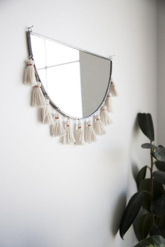 a semi circle mirror with tassels is a fantastic solution for a boho space, it will add a cool wild touch to the room
