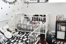 a small black and white shared room with some fun prints, cute toys and textiles plus a bunting