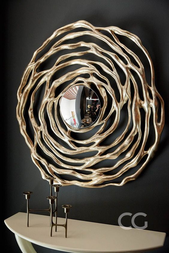 A small round mirror with a unique gold frame that resembles a flower is a lovely and catchy art inspired idea for a modern room