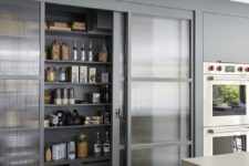 framed rain glass sliding doors hide the pantry and don’t look bulky separating the spaces
