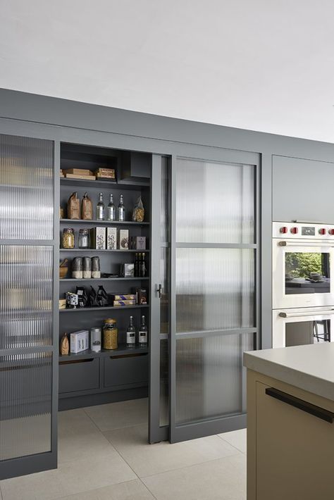 framed rain glass sliding doors hide the pantry and don't look bulky separating the spaces